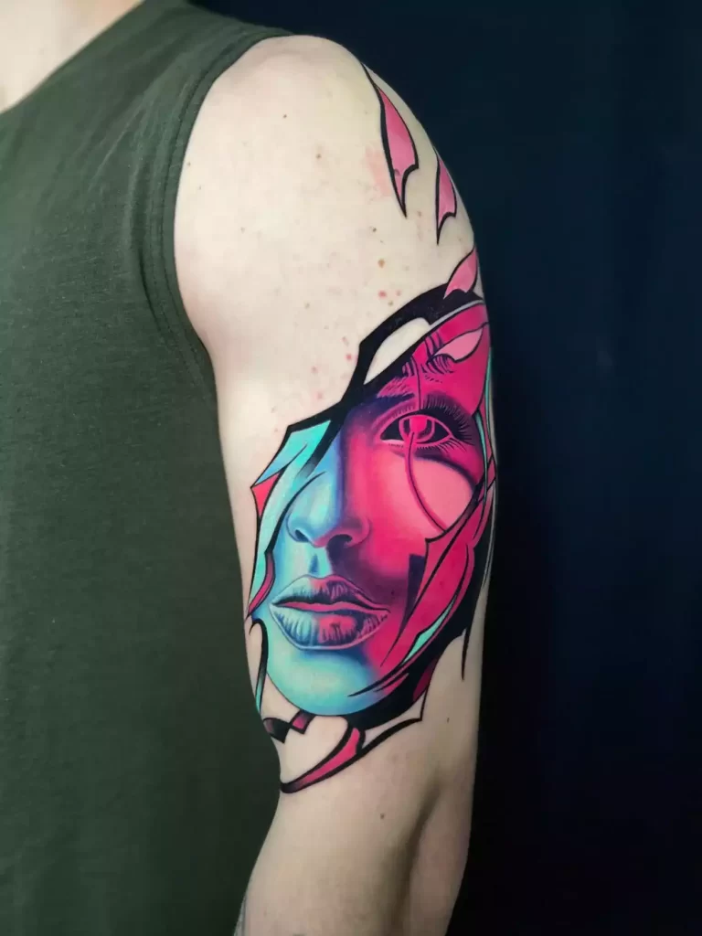 An abstract tattoo of a face with vibrant blue, pink, and purple tones. The design combines soft realism with sharp geometric shapes, creating a fragmented, modern effect.