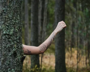 outdoor photo of a woman's arm with a flower tattoo