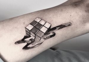 a melting Rubik's cube tattoo in chrome black and white.